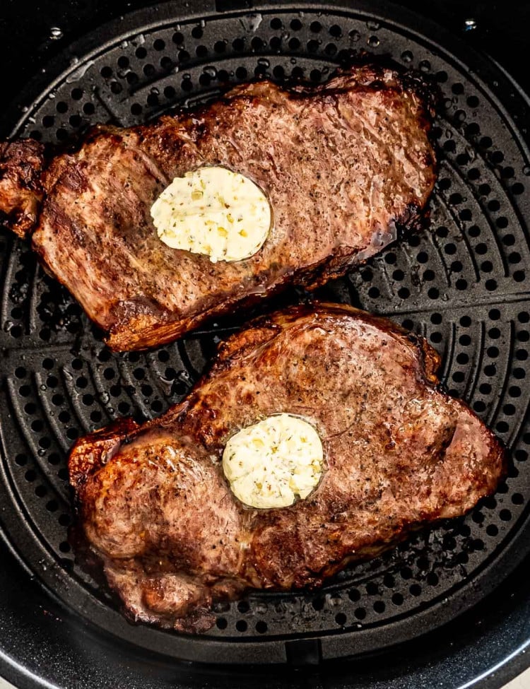 2 steaks with butter in an air fryer.