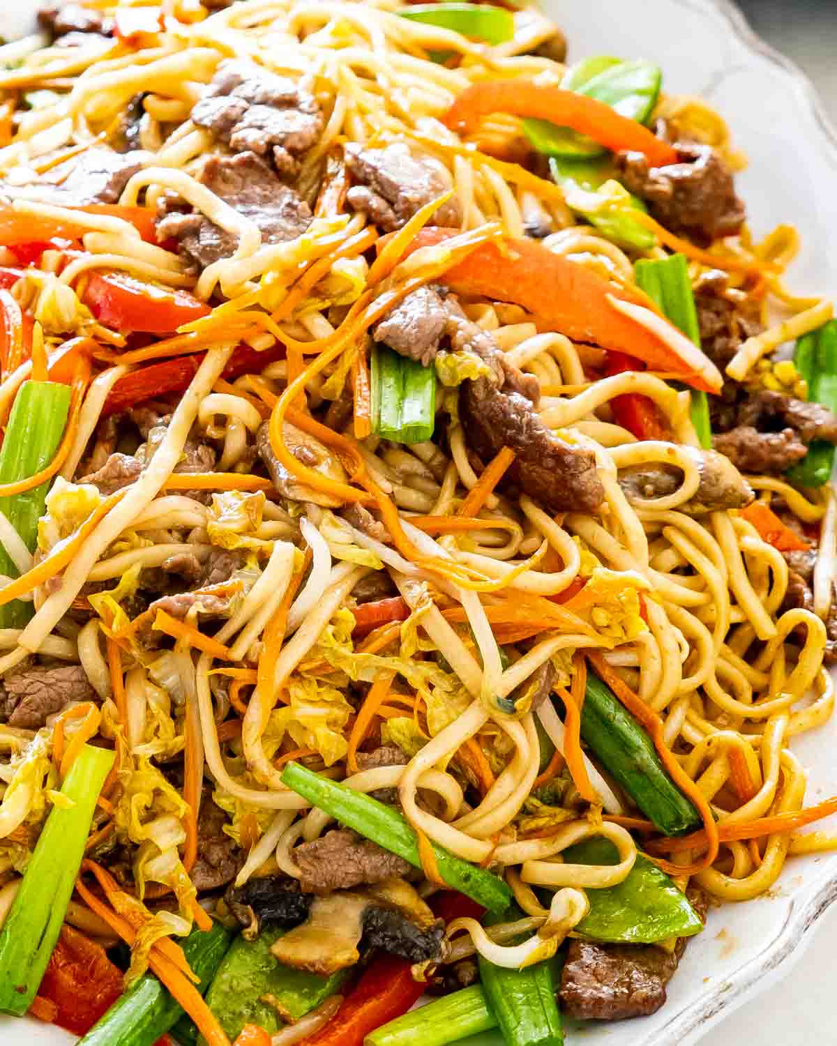 beef lo mein in a white serving platter.