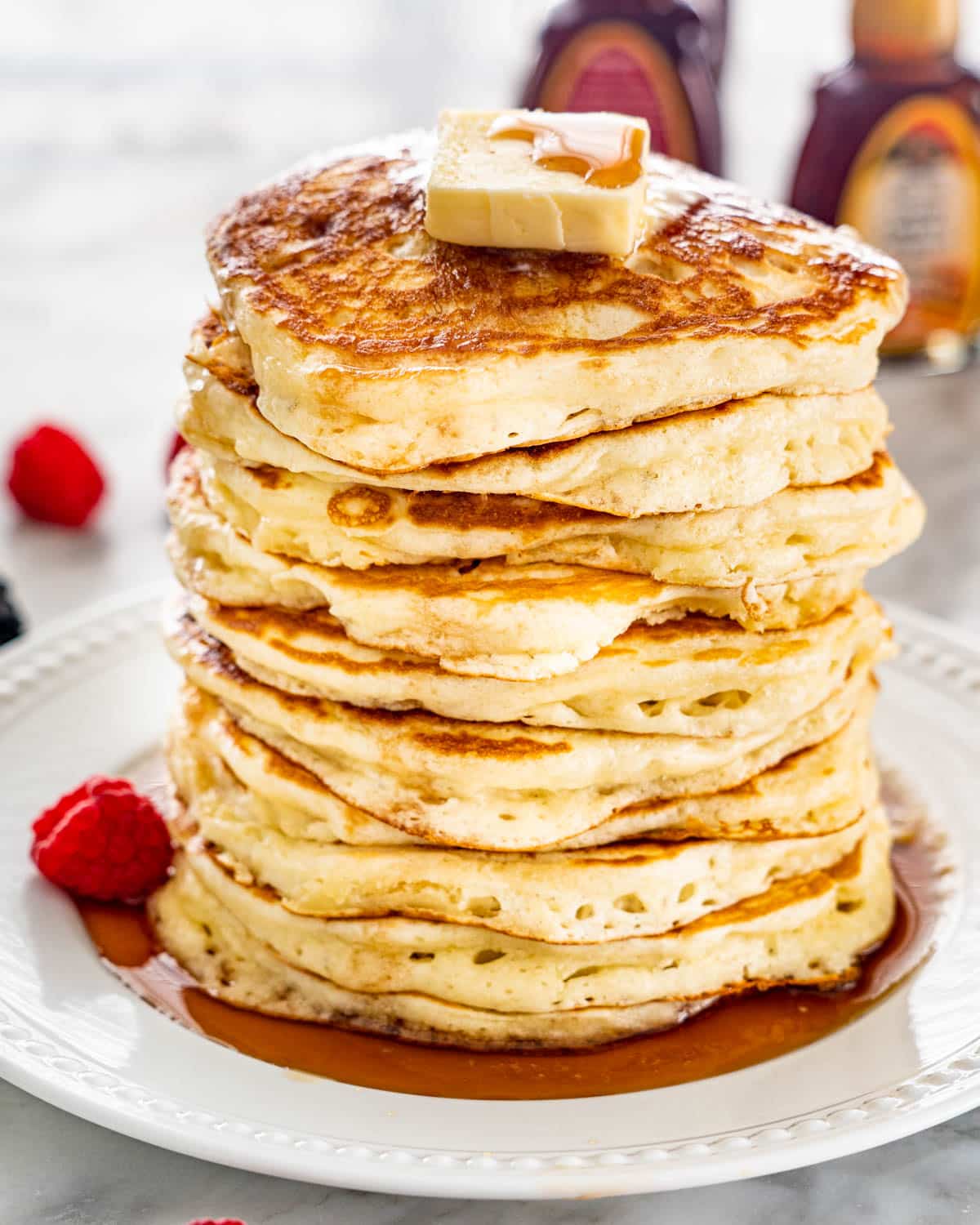 a stack of pancakes topped with butter and maple syrup