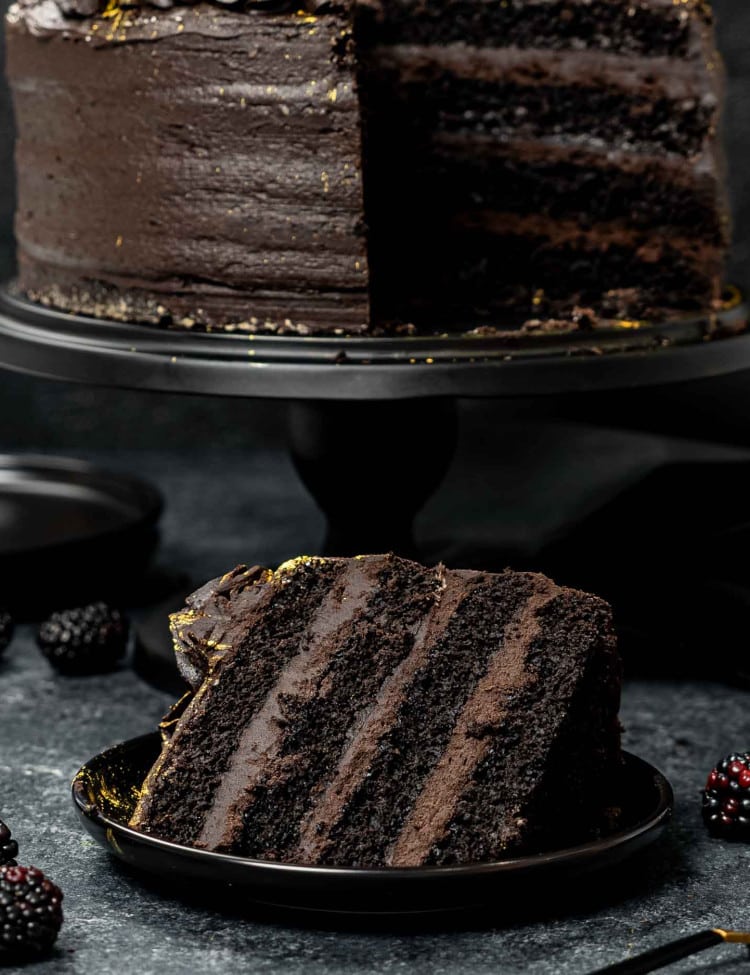 a slice of black velvet cake on a black plate.
