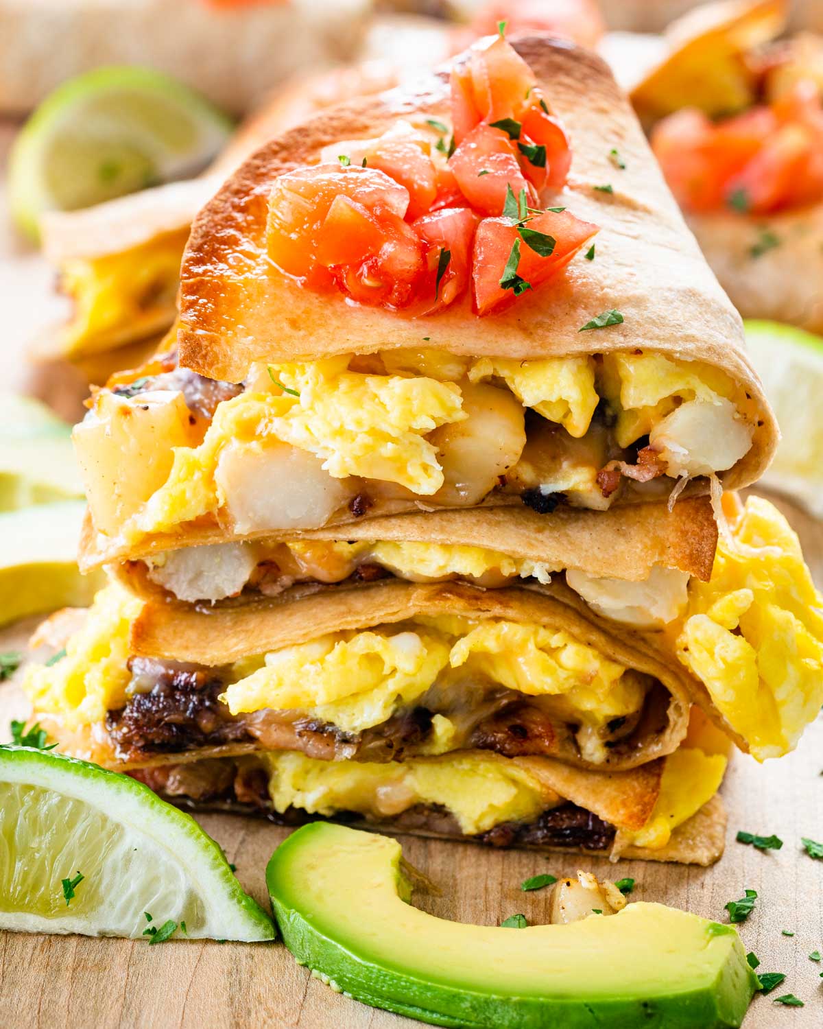 breakfast quesadilla pieces stacked and garnished with chopped tomatoes.