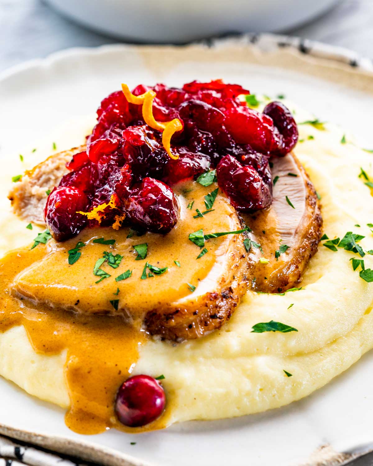 mashed potatoes with 2 slices of turkey breast. gravy and cranberry sauce.