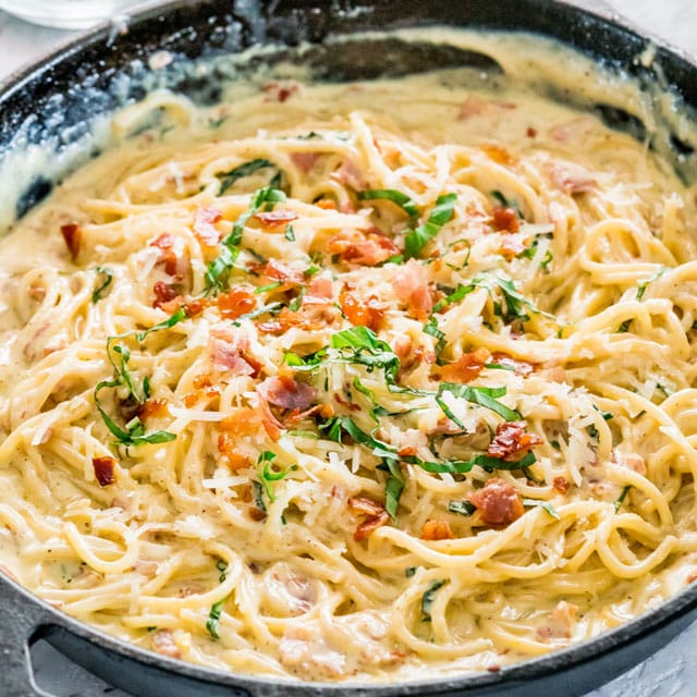 creamy carbonara in a cast iron skillet with pancetta coming through