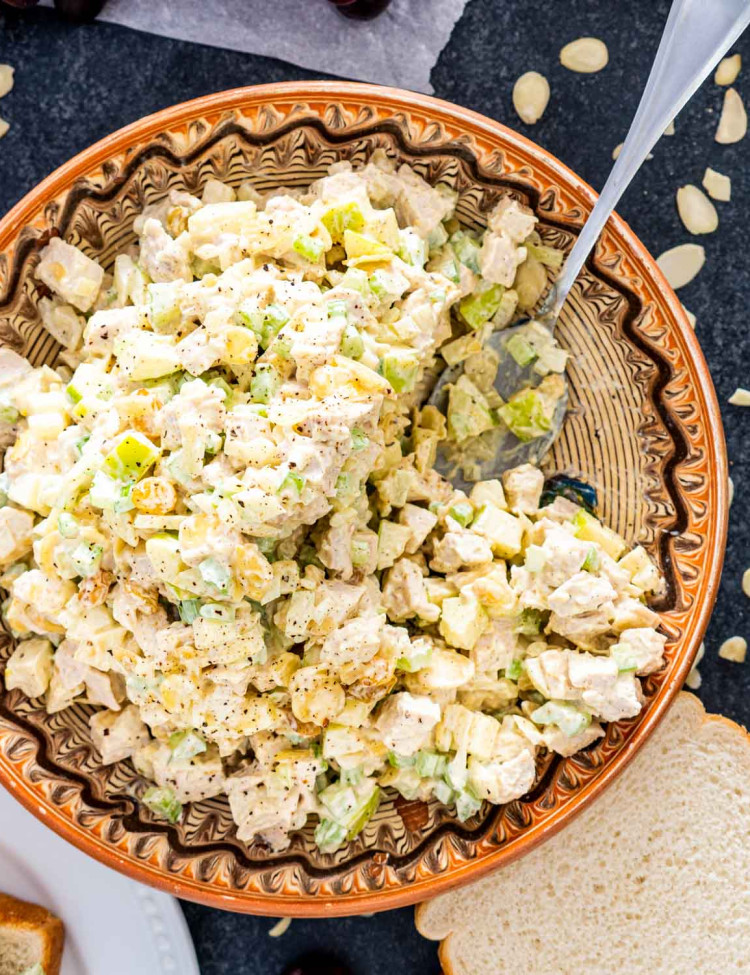 curry chicken salad in a bowl with a serving spoon inside.