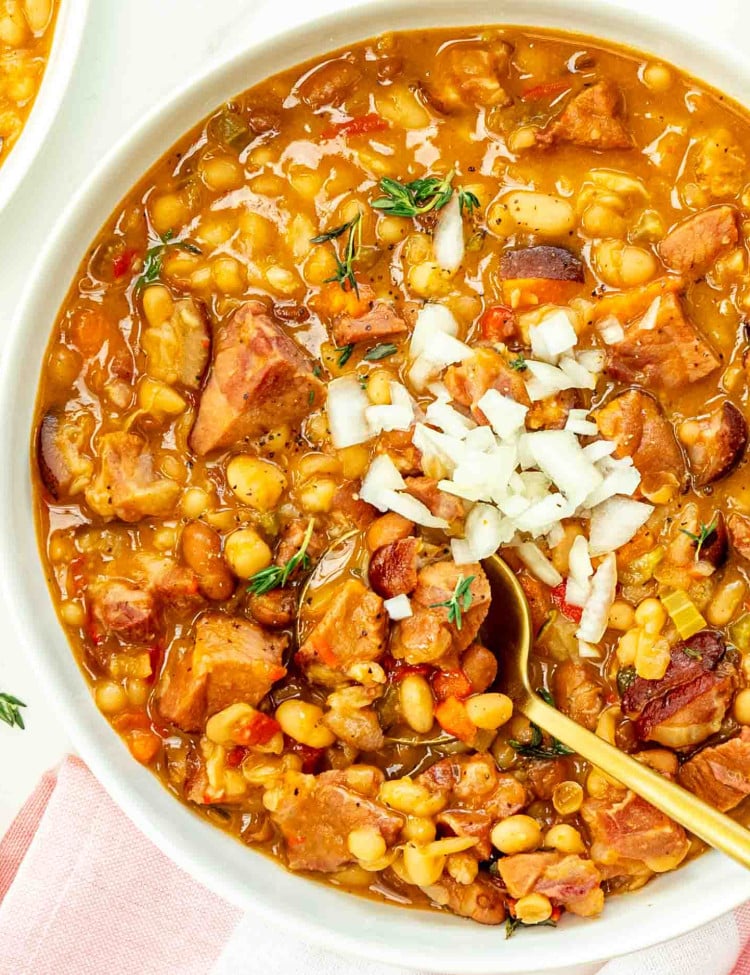 a big white bowl of mom's pork and beans topped with some chopped onion.