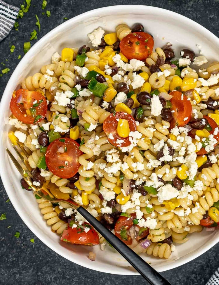 a serving of southwest pasta salad in a white bowl with a fork inside.